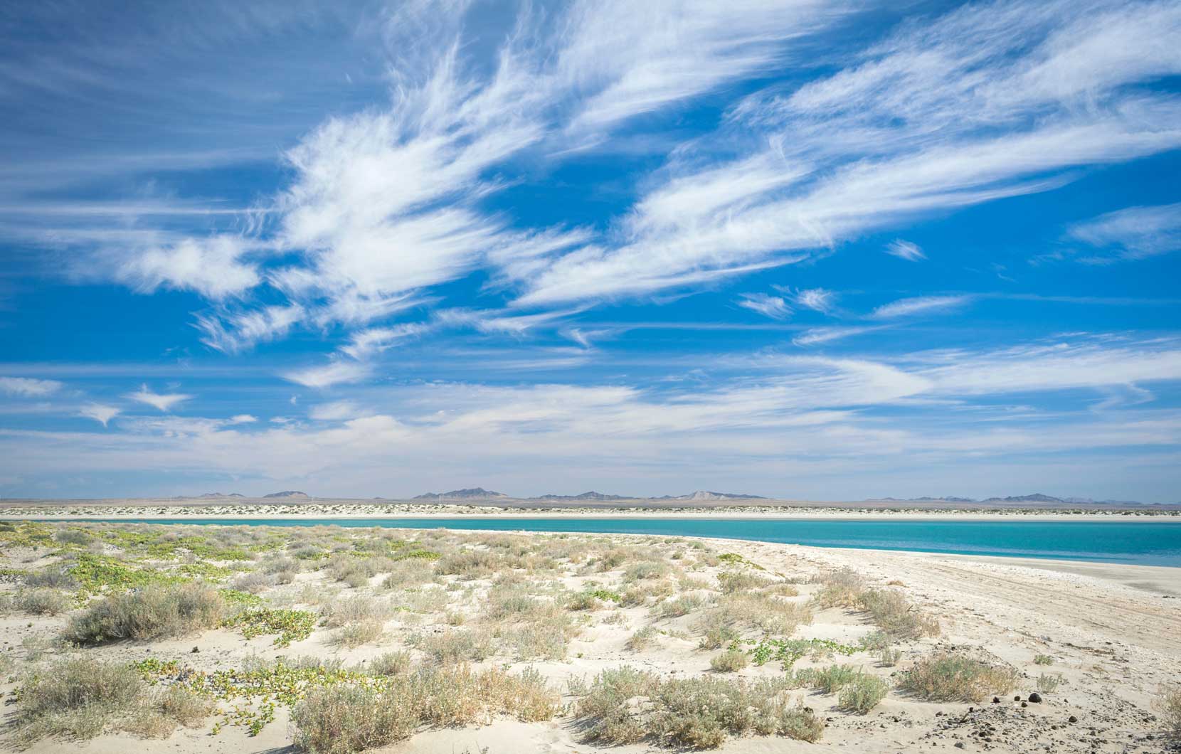 Stark, striking desert crashes endlessly against perfect turquoise seas.